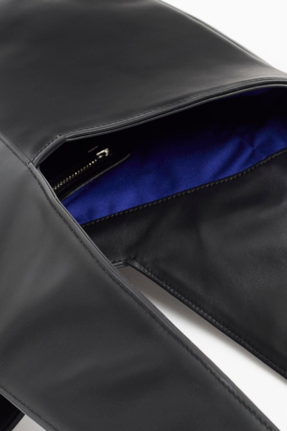 Interior details of AYT Studio 'FOULARD' tote bag made of black Italian leather and lining with zipped interior pocket, metal key hook, and handle with sophisticated scarf detail