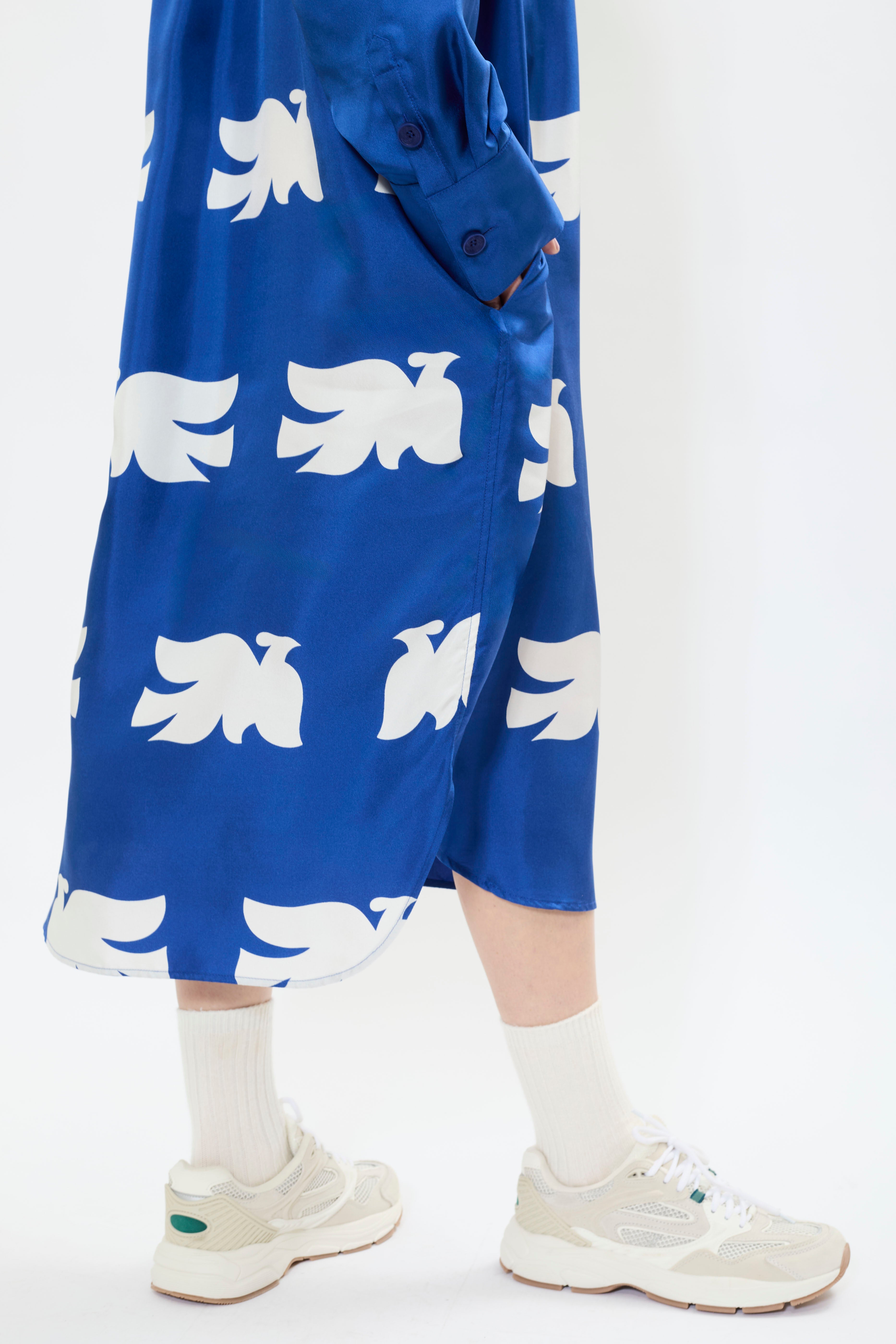 Details of AYT Studio x French artist REMED 'CLOUD OF BIRDS' 100% twill silk button shirt dress with structured collar, long sleeves, and discreet pockets. Lightweight and versatile for day-to-night, relaxed, feminine style. Inspired by REMED's 'Bel Envol.'