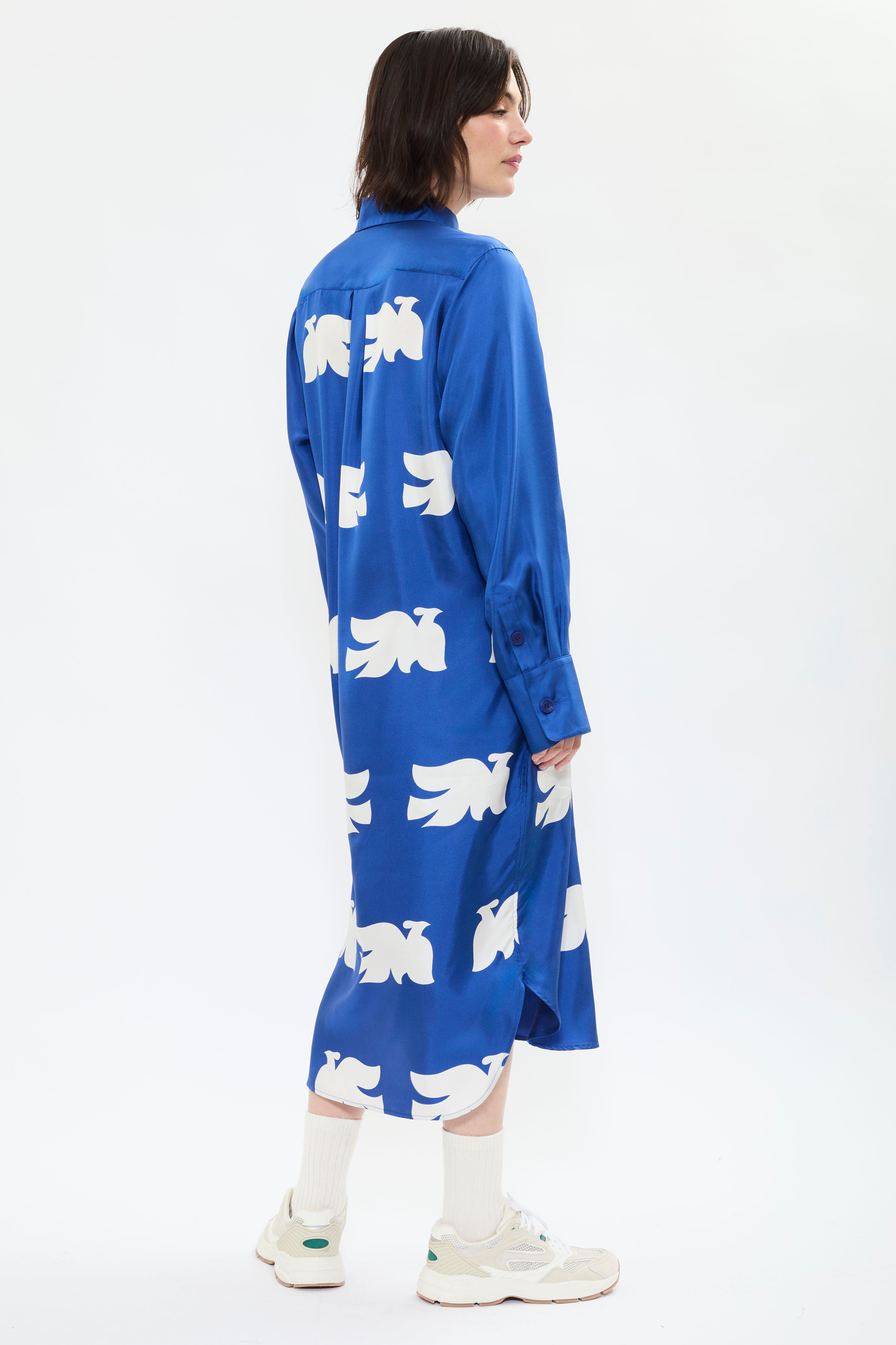 Back of AYT Studio x French artist REMED 'CLOUD OF BIRDS' 100% twill silk button shirt dress with structured collar, long sleeves, and discreet pockets. Lightweight and versatile for day-to-night, relaxed, feminine style. Inspired by REMED's 'Bel Envol.'