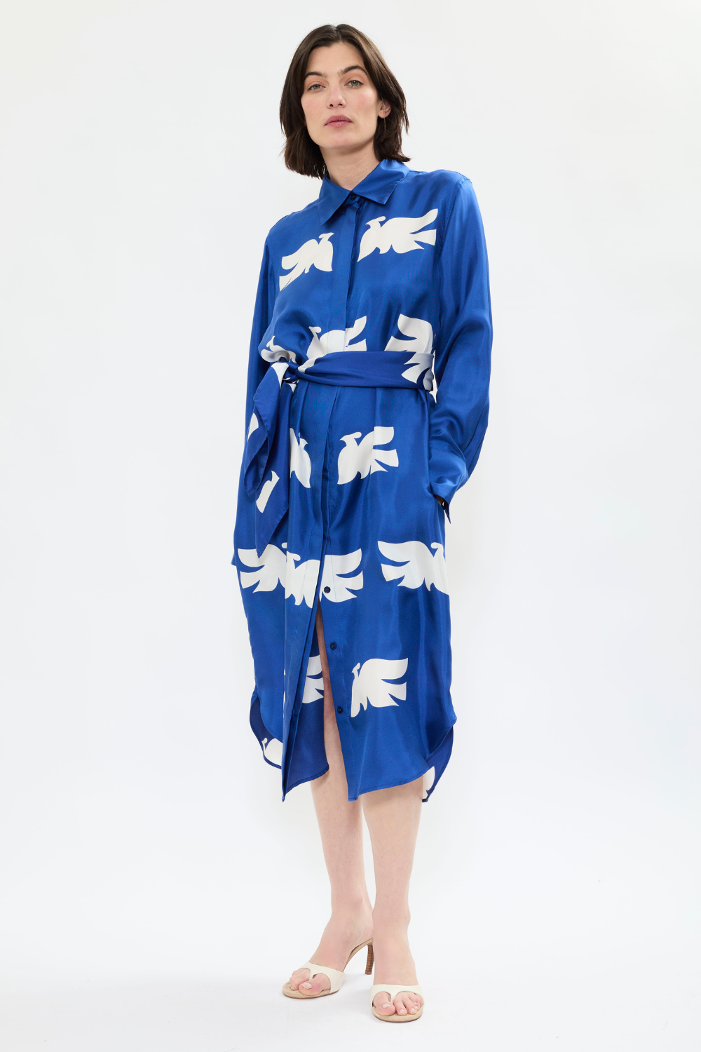 Model styling AYT Studio x French artist REMED 'CLOUD OF BIRDS' 100% twill silk button shirt dress with structured collar, long sleeves, and discreet pockets. Lightweight and versatile for day-to-night, relaxed, feminine style. Inspired by REMED's 'Bel Envol.'