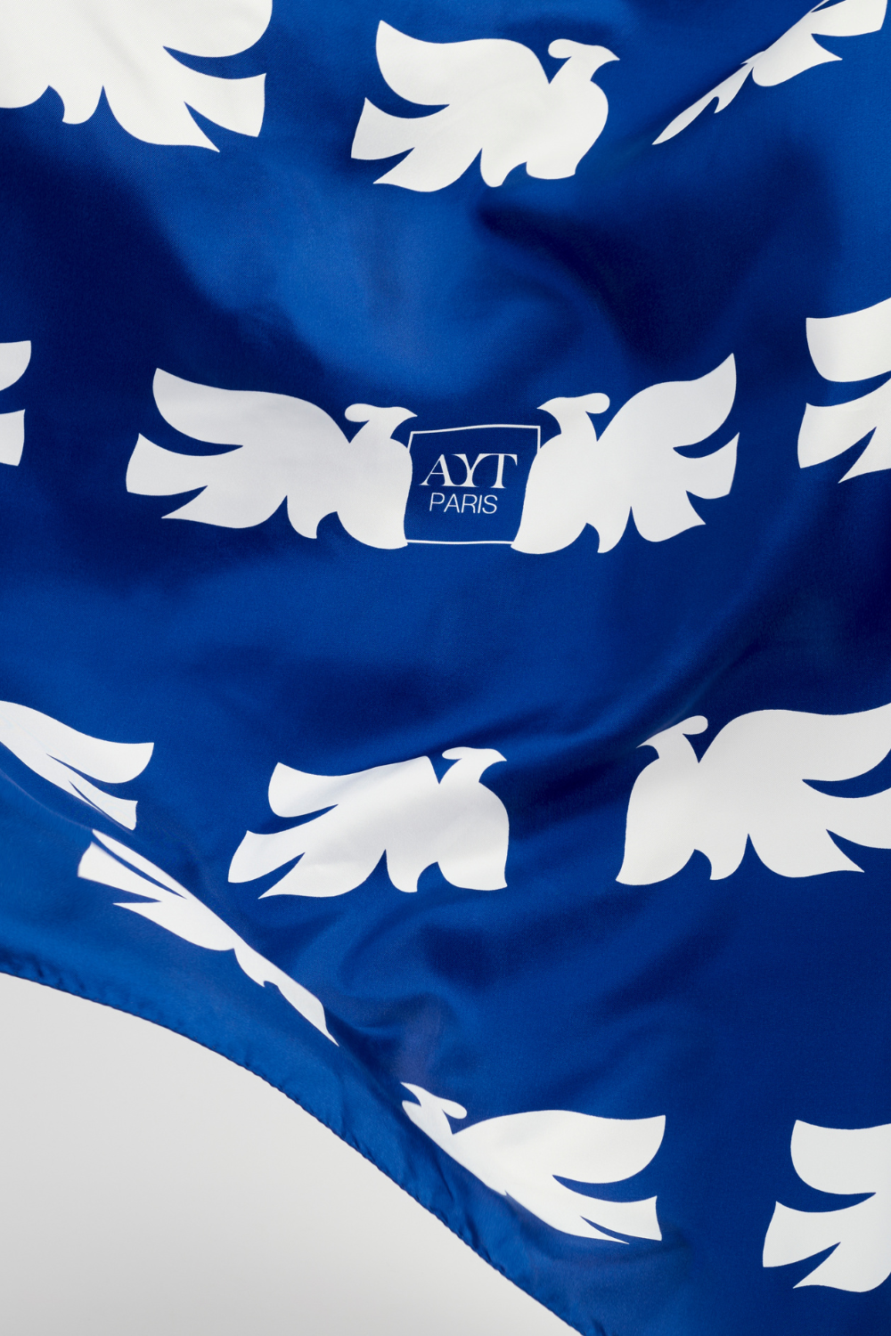 Details of AYT Studio x French artist REMED 'CLOUD OF BIRDS' 100% twill silk scarf crafted in Como, Italy, hand-finished with rolled edges and oversized graphic print. 100 x 100 cm. Lightweight, versatile accessory. Inspired by 'Bel Envol'