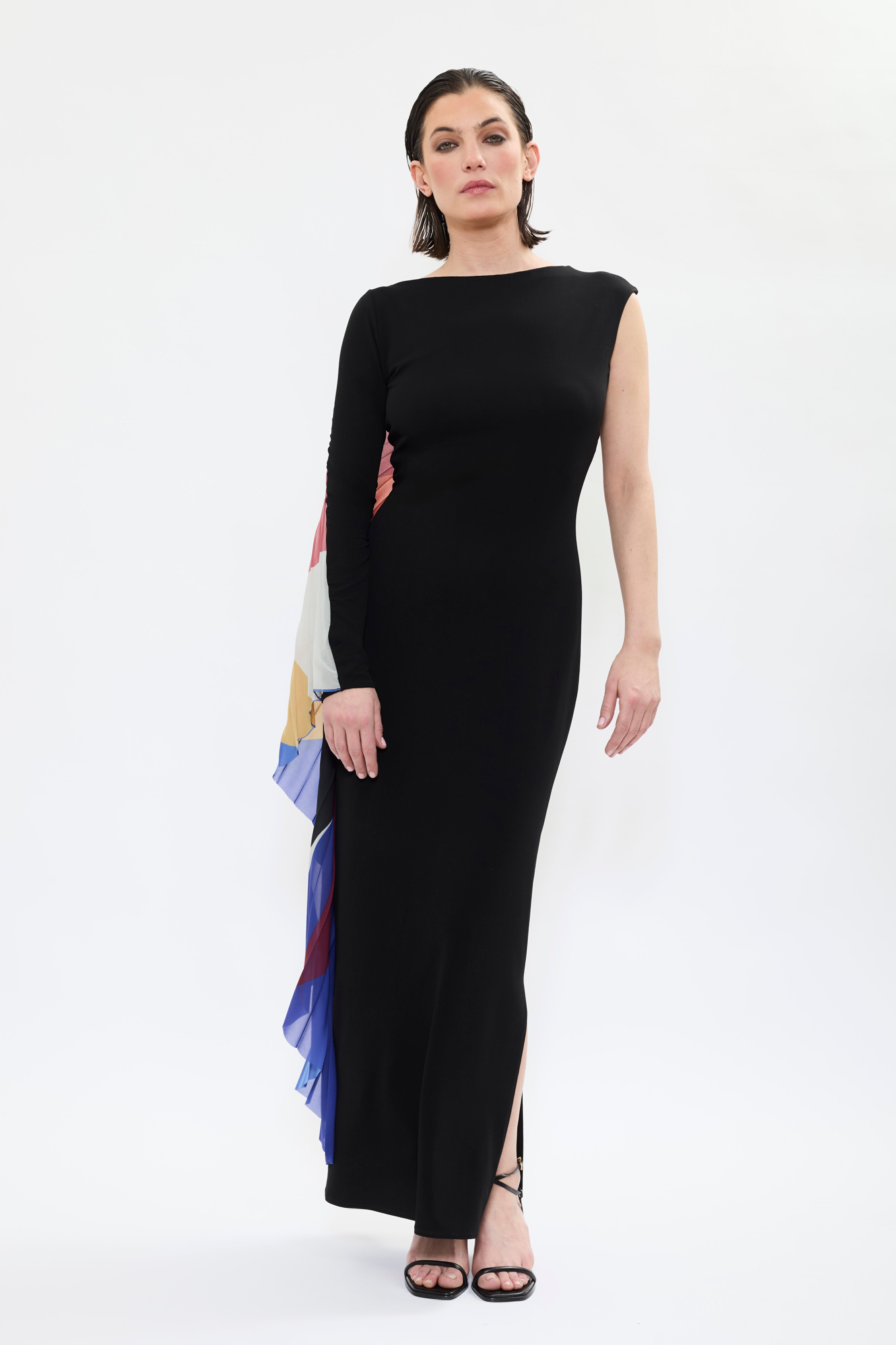 Model wearing AYT STUDIO x French painter REMED 'ENVOL' long, maxi dress in a fluid jersey fabric with asymmetrical single sleeve, pleated, sculptural graphic patterned panel. Inspired by the painting 'Bel Envol.'