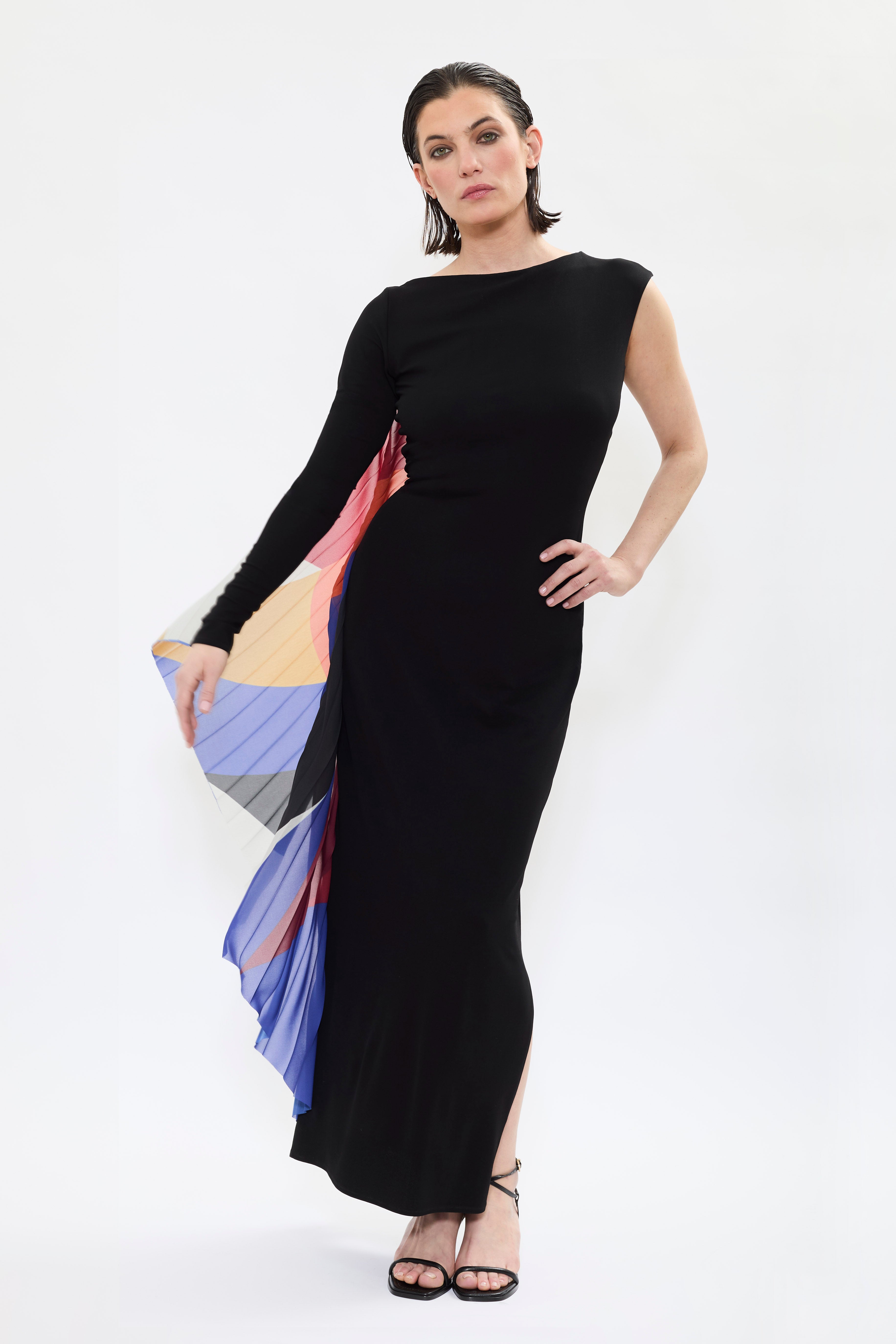 Model highlighting long sleeve and panel details of AYT STUDIO x French painter REMED 'ENVOL' long, maxi dress in a fluid jersey fabric with asymmetrical single sleeve, pleated, sculptural graphic patterned panel. Inspired by the painting 'Bel Envol.'