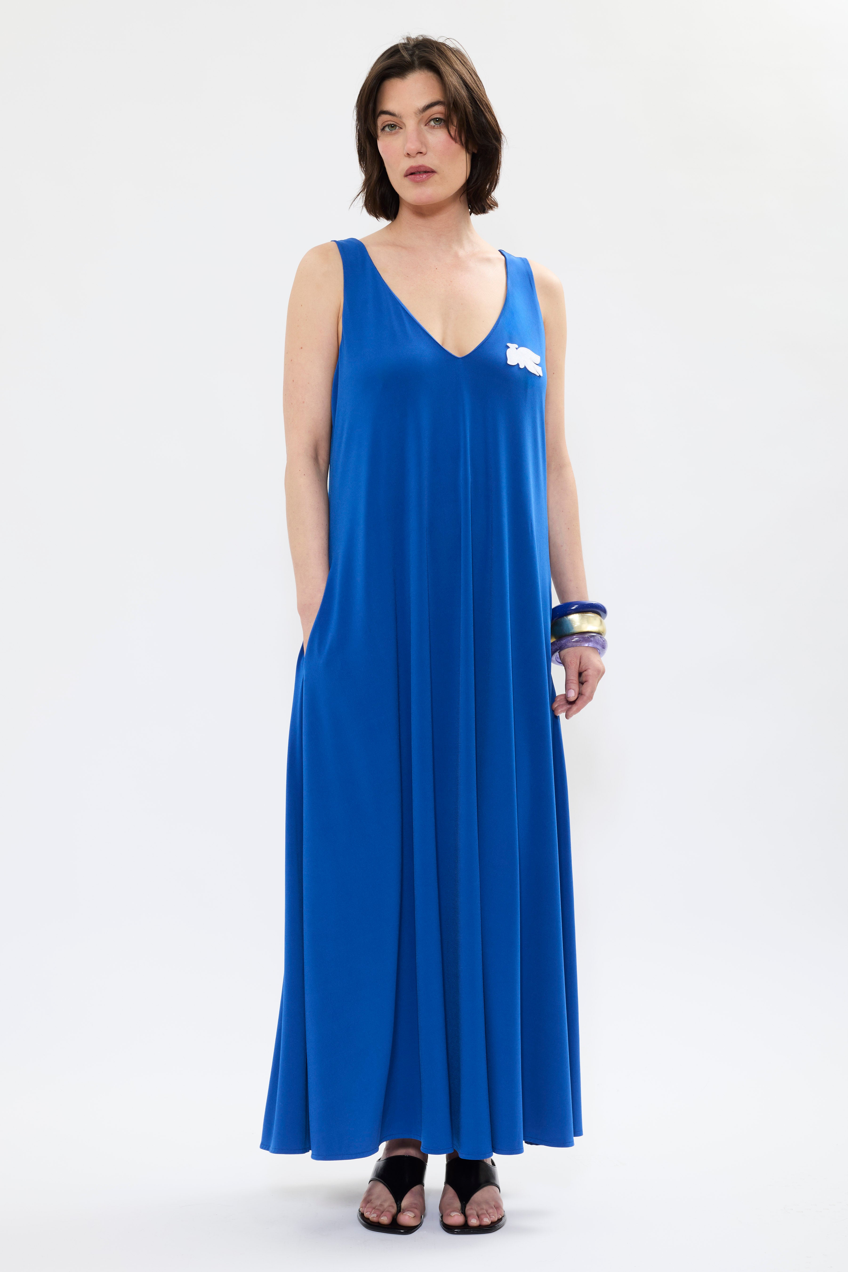 AYT Studio x French artist REMED 'MIRAGE' fluid blue dress in with plunging V-neck front and back, discreet side pockets, and white bird embroidery. Inspired by REMED's 'Ben Envol.'