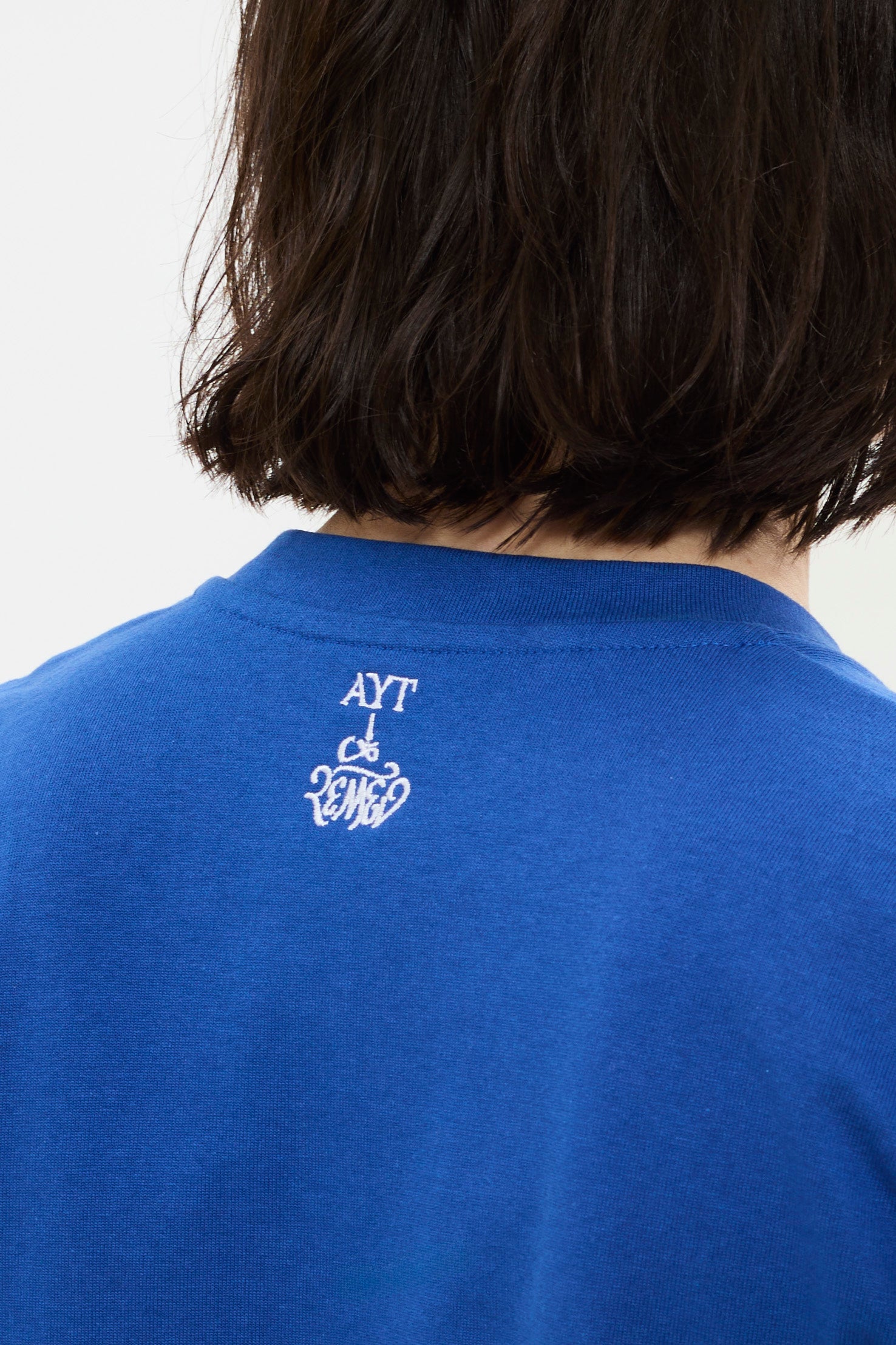 Embroidered details of AYT Studio x French artist REMED 'MIRAGE' blue 100% organic cotton T-shirt with straight fit, round neckline, and blue bird embroidery inspired by Remed's painting 'Bel Envol.'