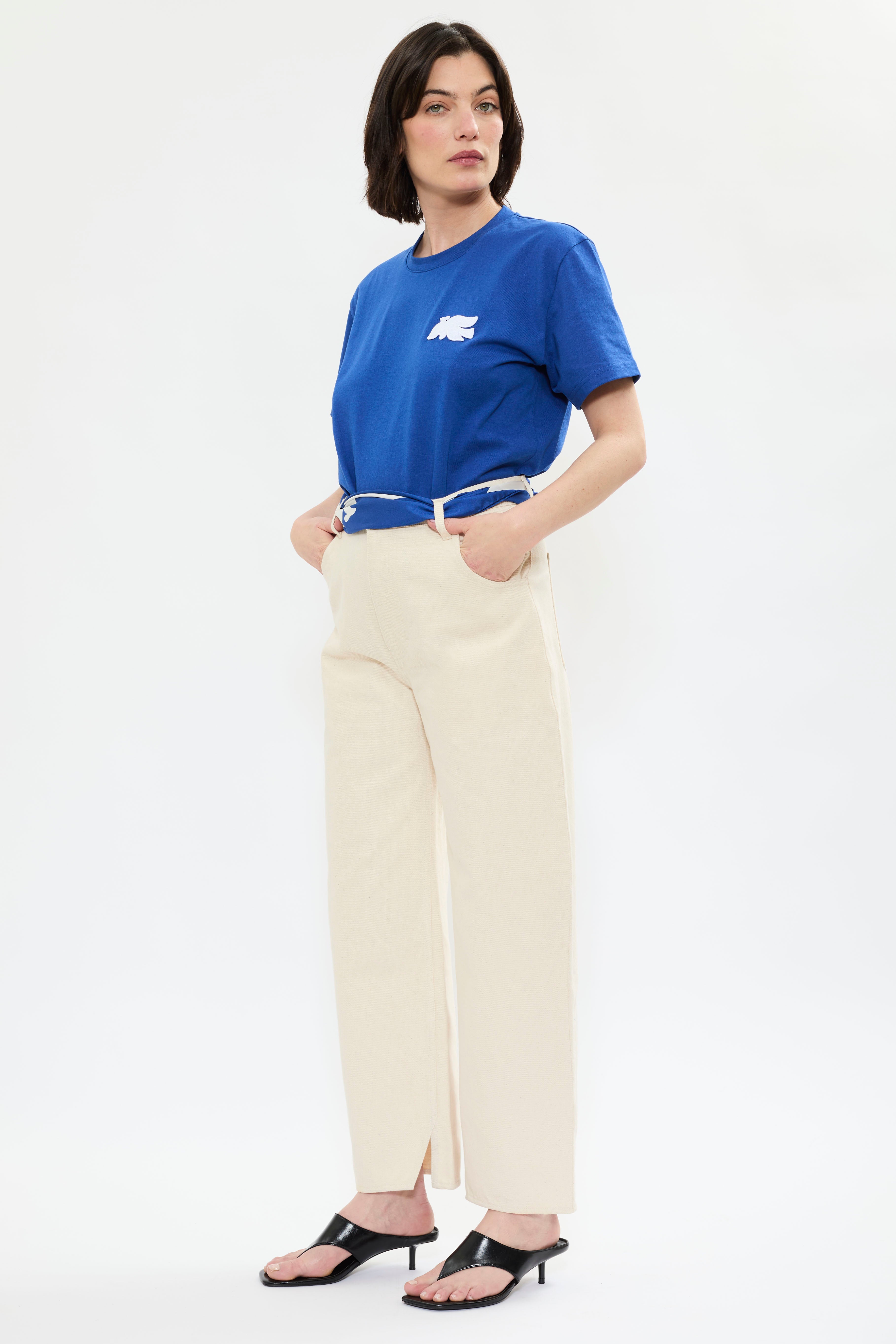 Profile of AYT Studio x French artist REMED 'MIRAGE' blue 100% organic cotton T-shirt  with straight fit, round neckline, and blue bird embroidery inspired by Remed's painting 'Bel Envol.'