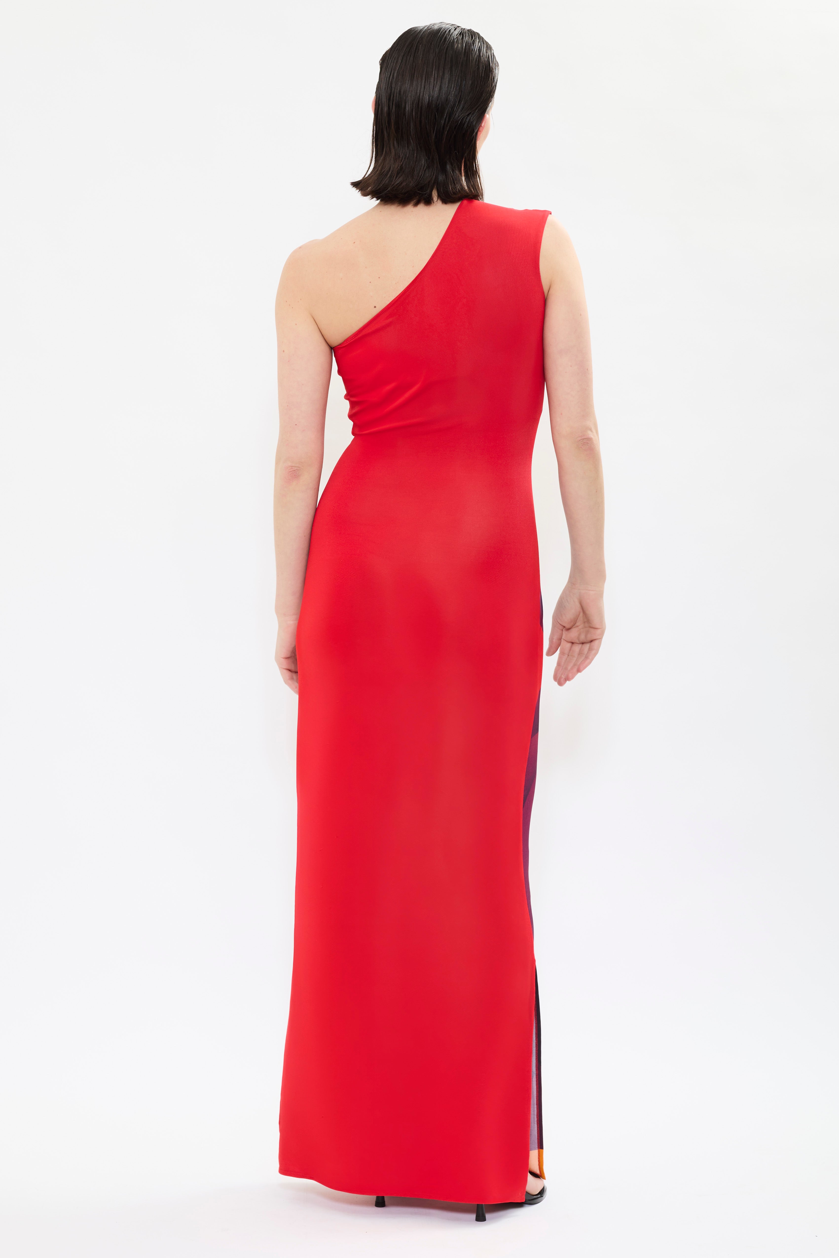 Rear view of AYT STUDIO x REMED ‘Muse’ one-shoulder maxi dress in fluid viscose with sculptural sleeve and red, black and orange bold artistic print inspired by 'El lago intimo.'