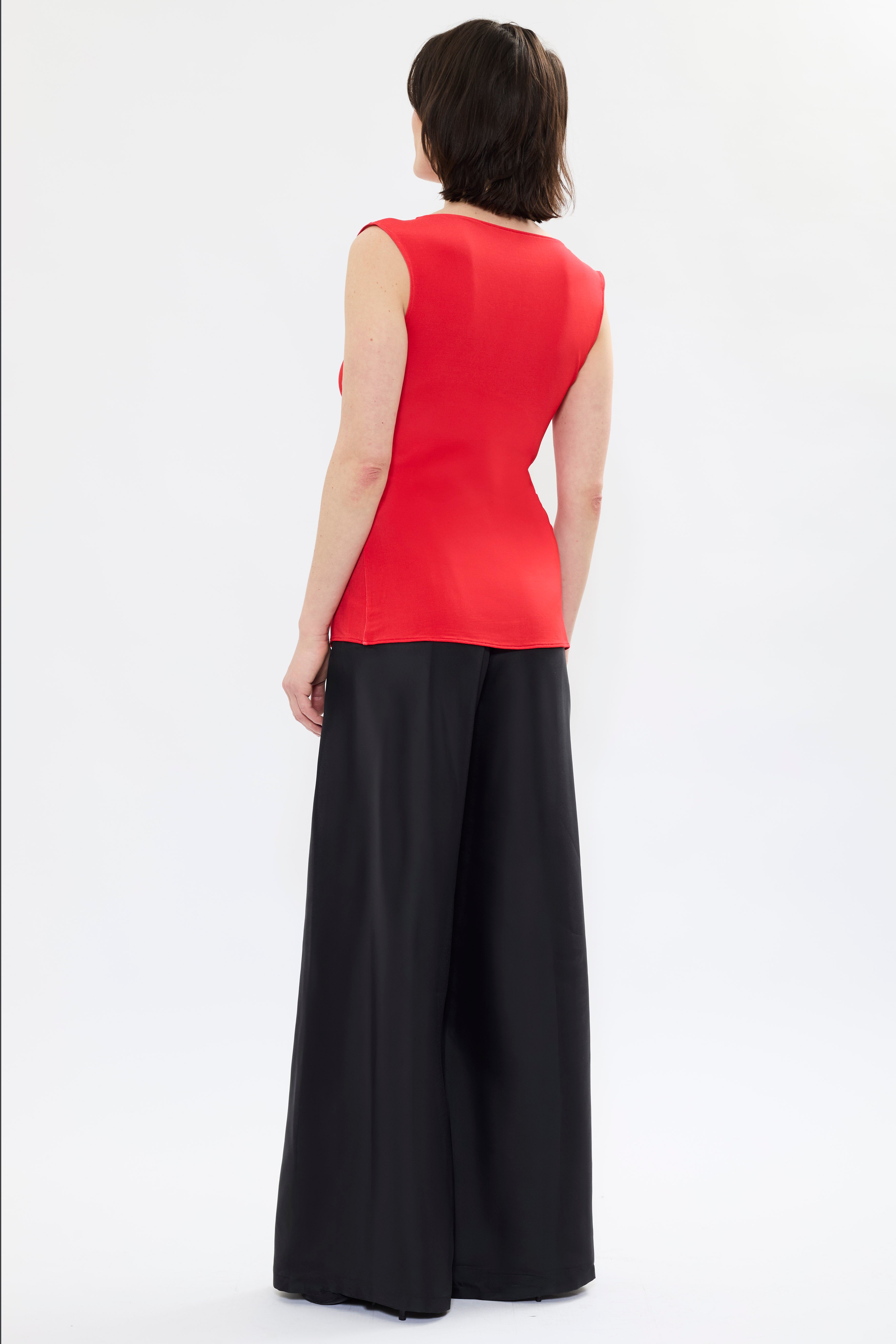 Rear view of AYT STUDIO X REMED 'MUSE' tank top in deep reds and black with a fitted, sleeveless silhouette, and boat neckline that highlight the elegance of the cut with a bold artistic print.