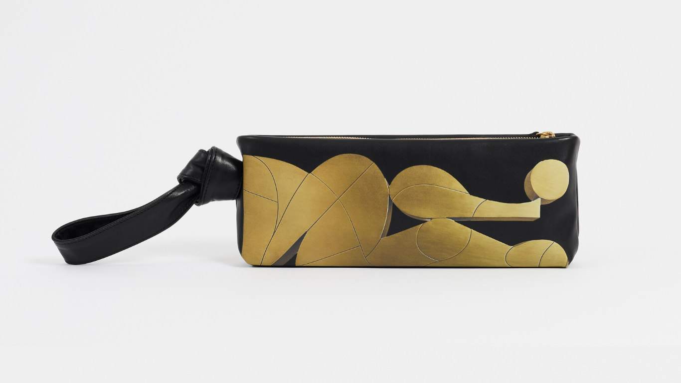 Black clutch with gold abstract designs on a white background