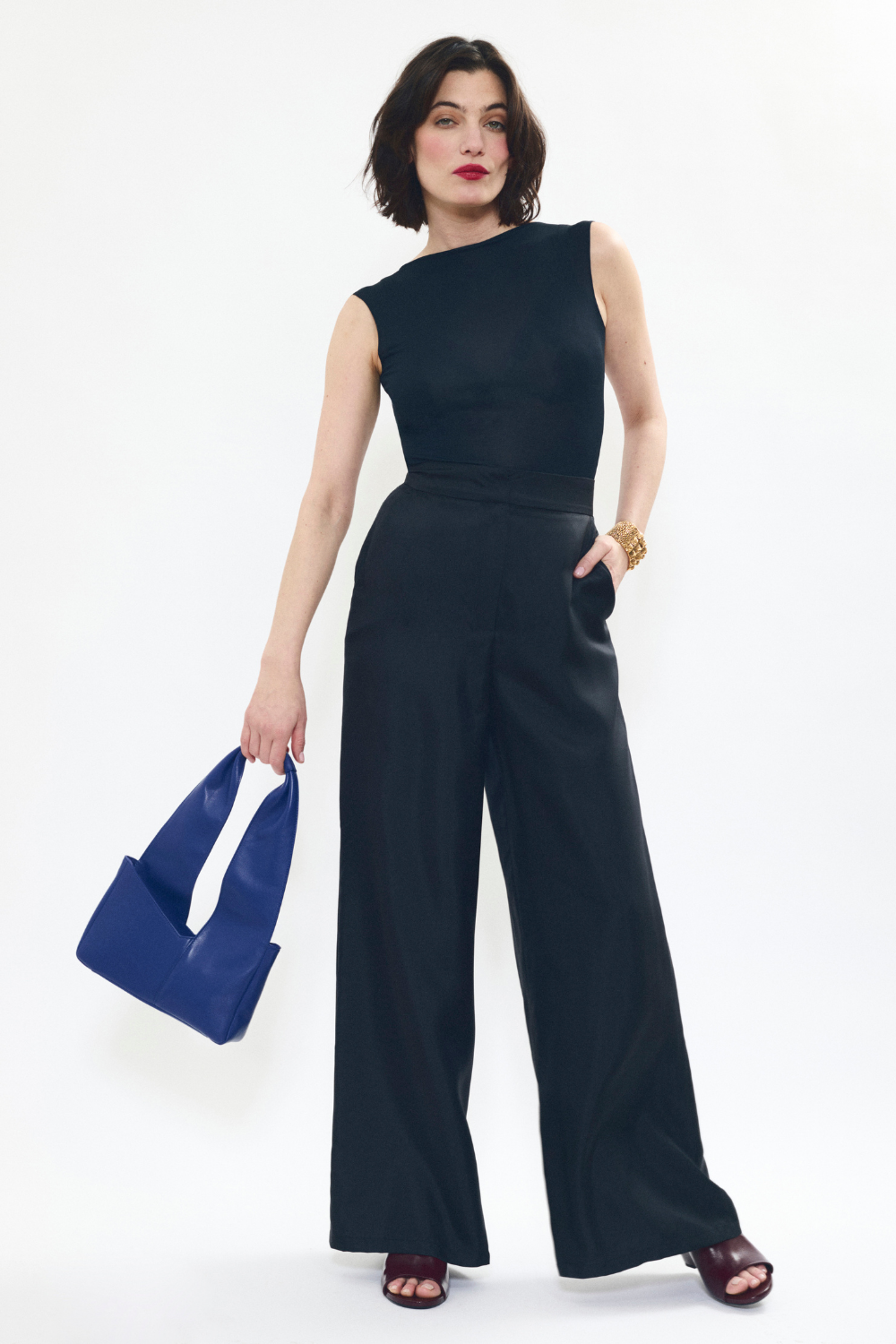 Model holding AYT Studio 'Dual' tote bag made of blue Italian leather and lining with full-length zipper, handle with sophisticated scarf detail