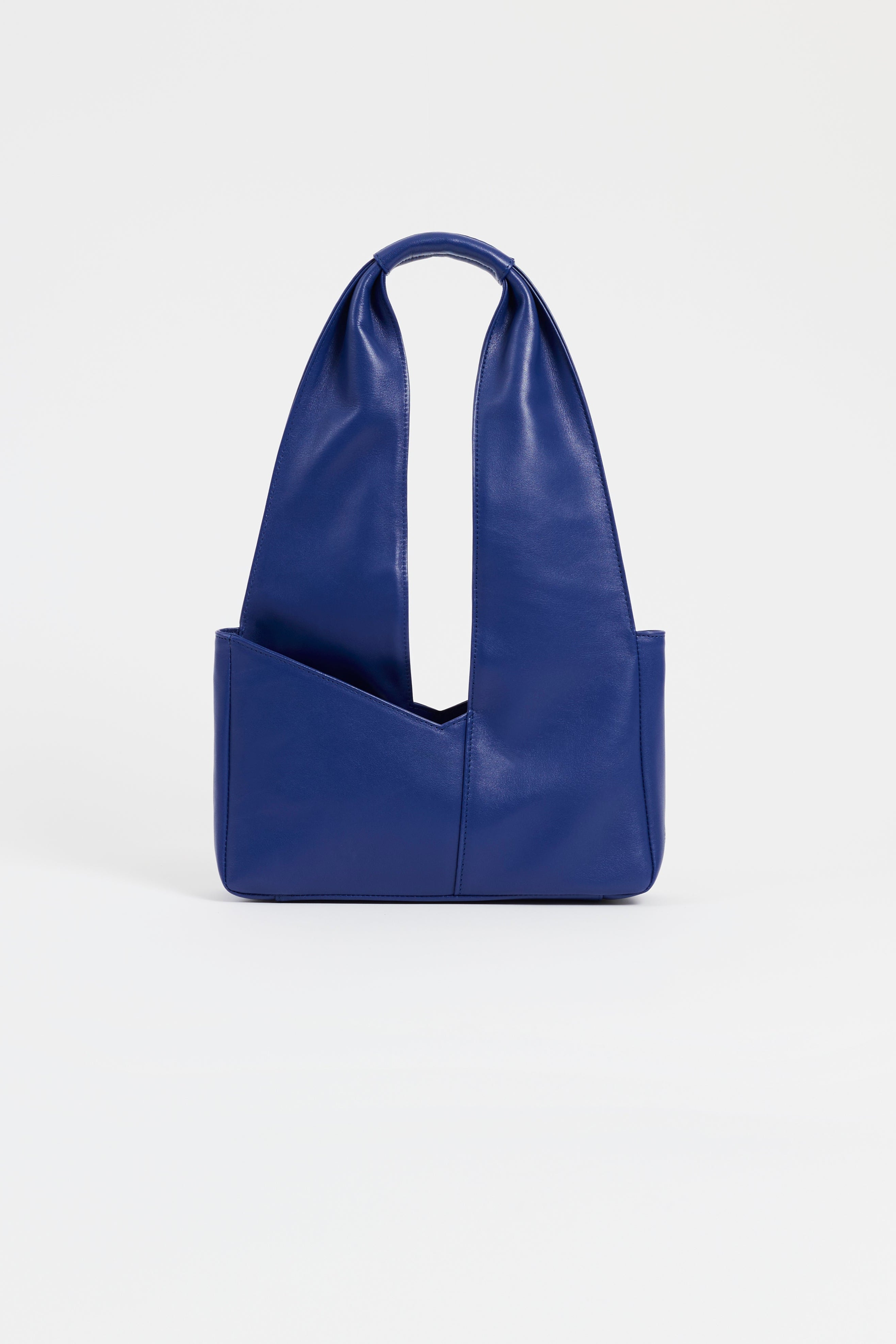 Front view of AYT Studio 'Dual' tote bag made of blue Italian leather and lining with full-length zipper, handle with sophisticated scarf detail