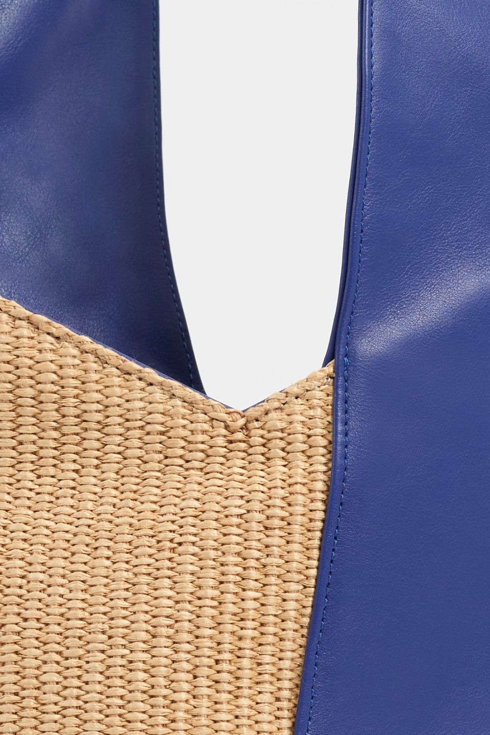 Material of AYT Studio 'FOULARD' tote bag made of blue leather, natural raffia, and blue canvas lining with zipped interior pocket, metal key hook, and  handle with sophisticated scarf detail