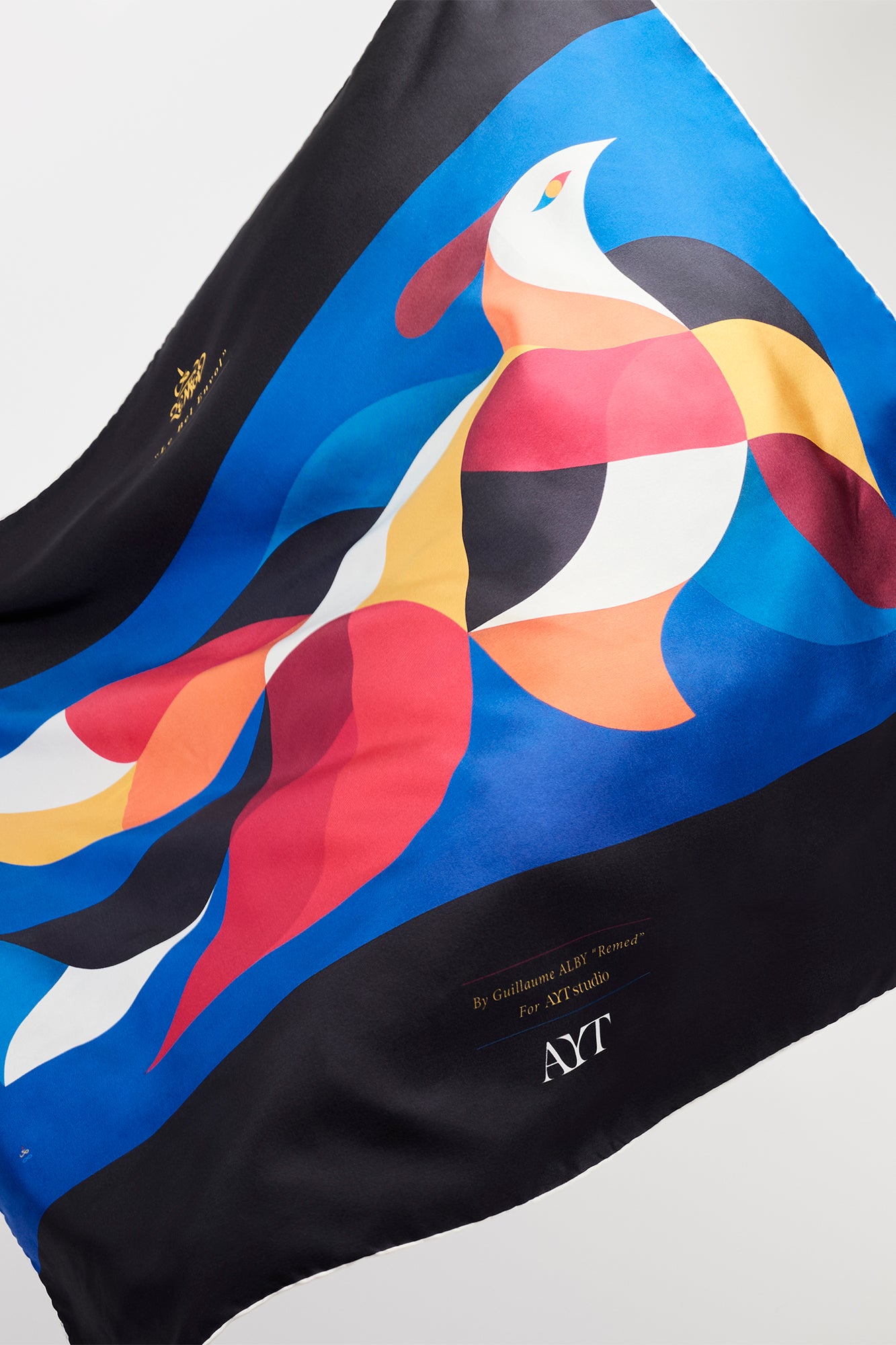 AYT STUDIO x French painter REMED 100% twill silk scarf crafted in Como, Italy in a stylized, colorful graphic print inspired by REMED's painting  ‘Bel Envol.' Fluid, versatile accessory for styling. 85 x 85 cm.