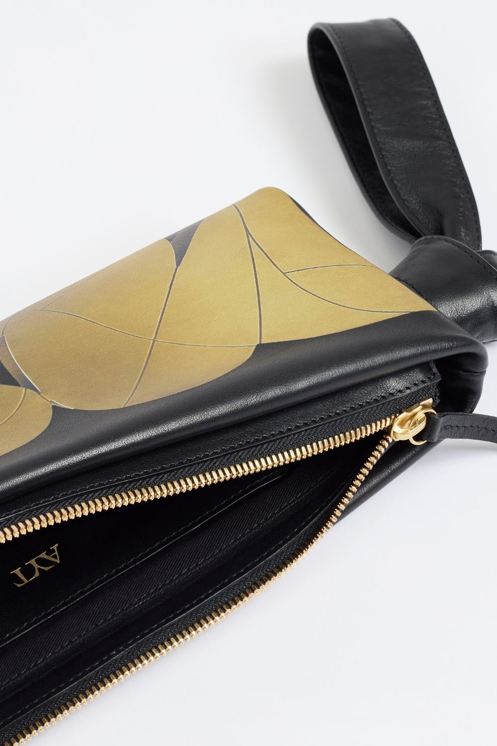 Details of AYT Studio x Remed 'FOULARD' black leather baguette bag with a copper-inspired artistic print, a scarf-inspired wrist strap, and gold hardware.