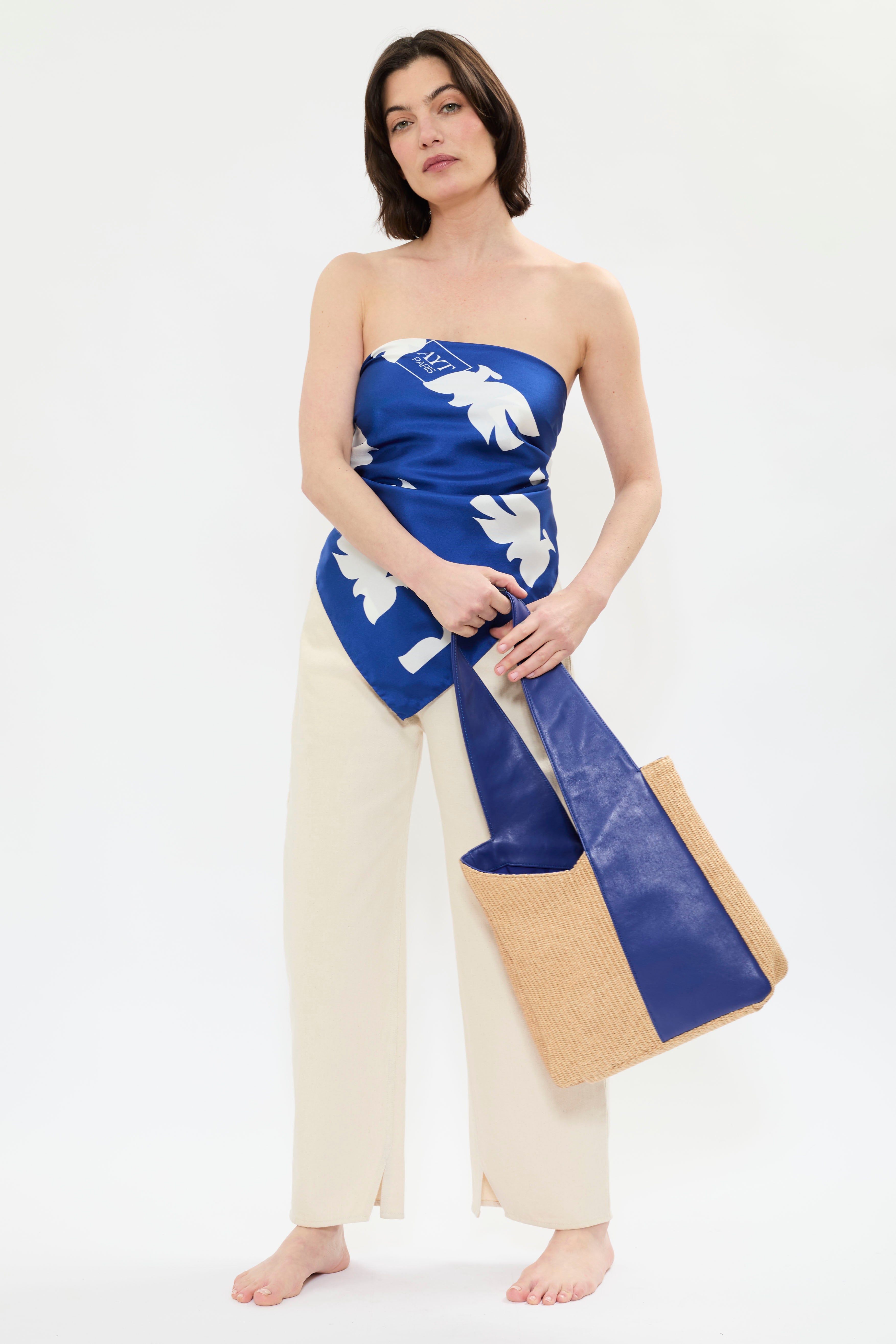 Model wearing AYT Studio x French artist REMED 'CLOUD OF BIRDS' 100% twill silk scarf crafted in Como, Italy, hand-finished with rolled edges and oversized graphic print. 100 x 100 cm. Lightweight, versatile accessory. Inspired by 'Bel Envol'