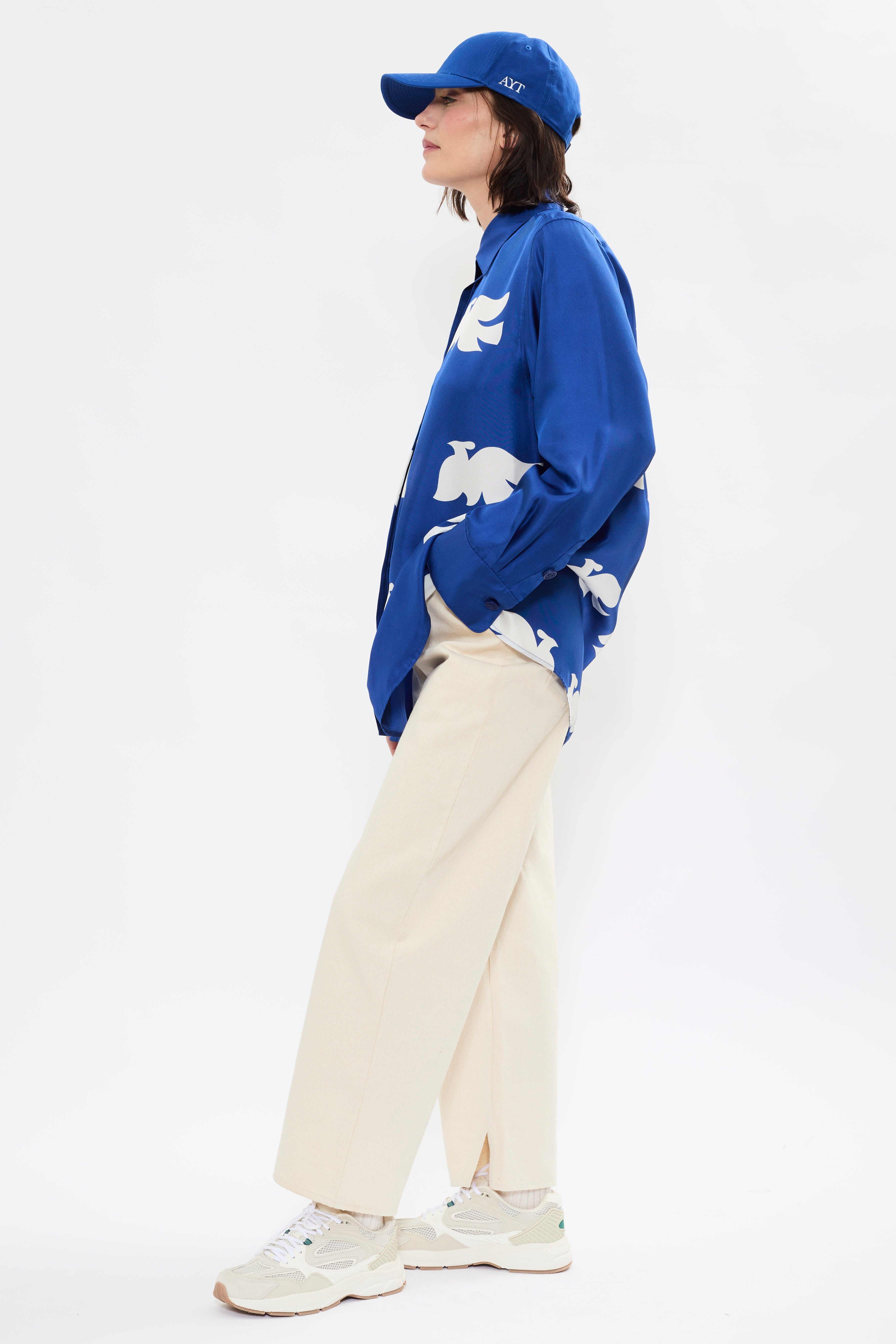 Side of AYT Studio x French artist REMED 'CLOUD OF BIRDS' 100% twill silk button down shirt with structured collar, long sleeves. Lightweight and versatile for day-to-night, relaxed, unisex style. Inspired by REMED's 'Bel Envol.'