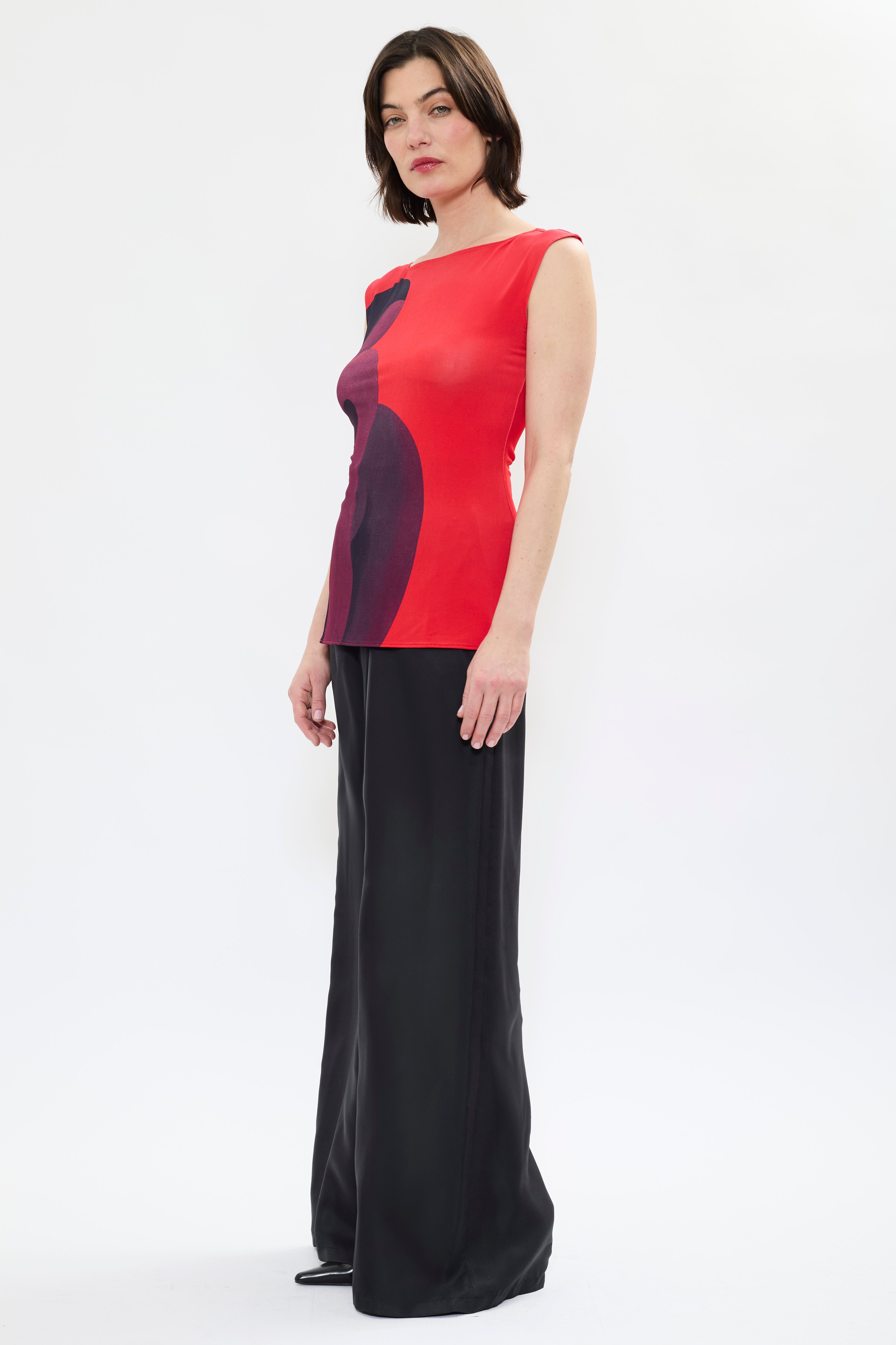 Side of AYT STUDIO X REMED 'MUSE' tank top in deep reds and black with a fitted, sleeveless silhouette, and boat neckline that highlight the elegance of the cut with a bold artistic print.