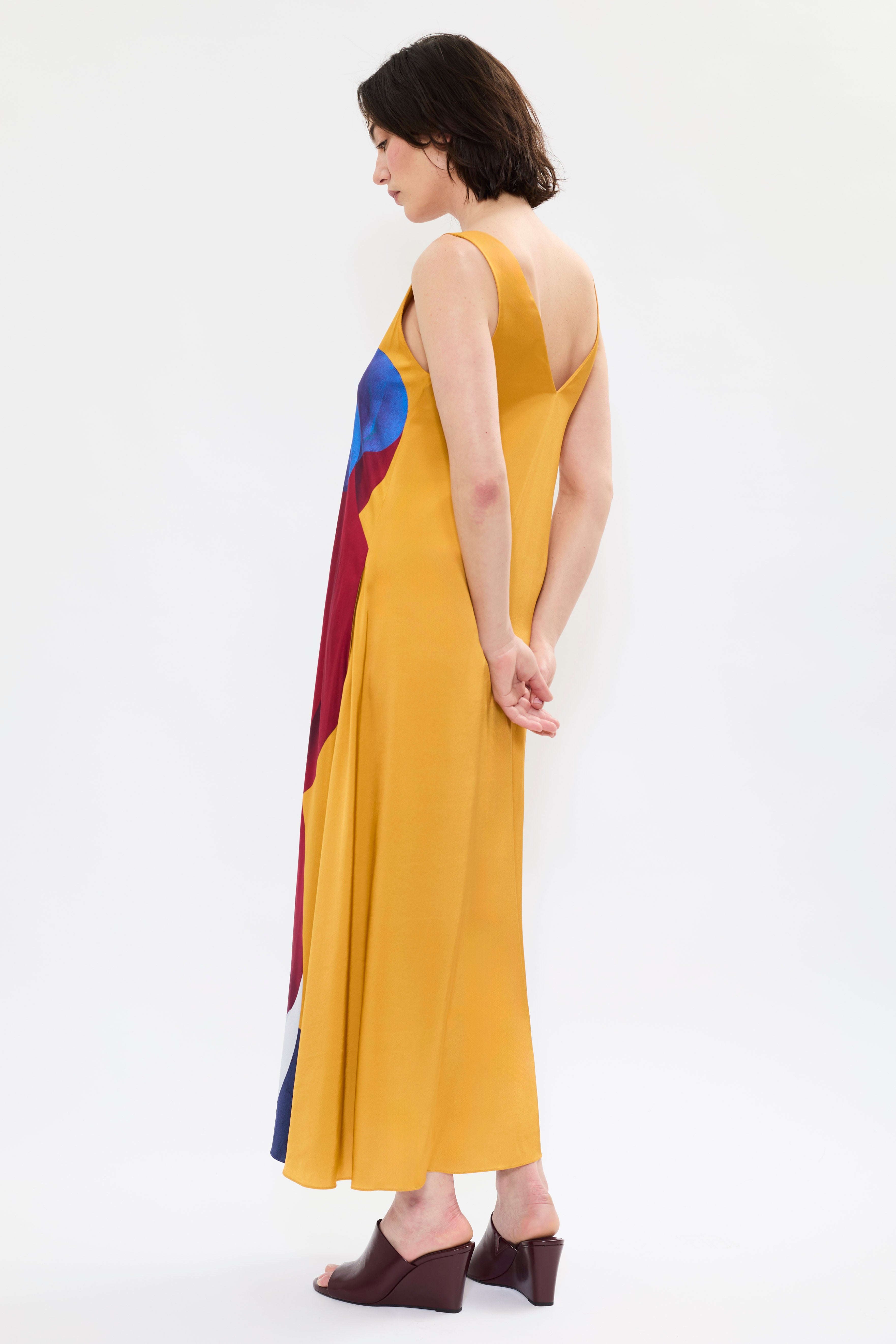 Rear of AYT Studio x French artist REMED 'SORORITY' fluid, vibrant yellow printed dress in viscose and elastane with punging V-neck front and back and discreet side pockets. Inspired by REMED's 'Bain de sable.'