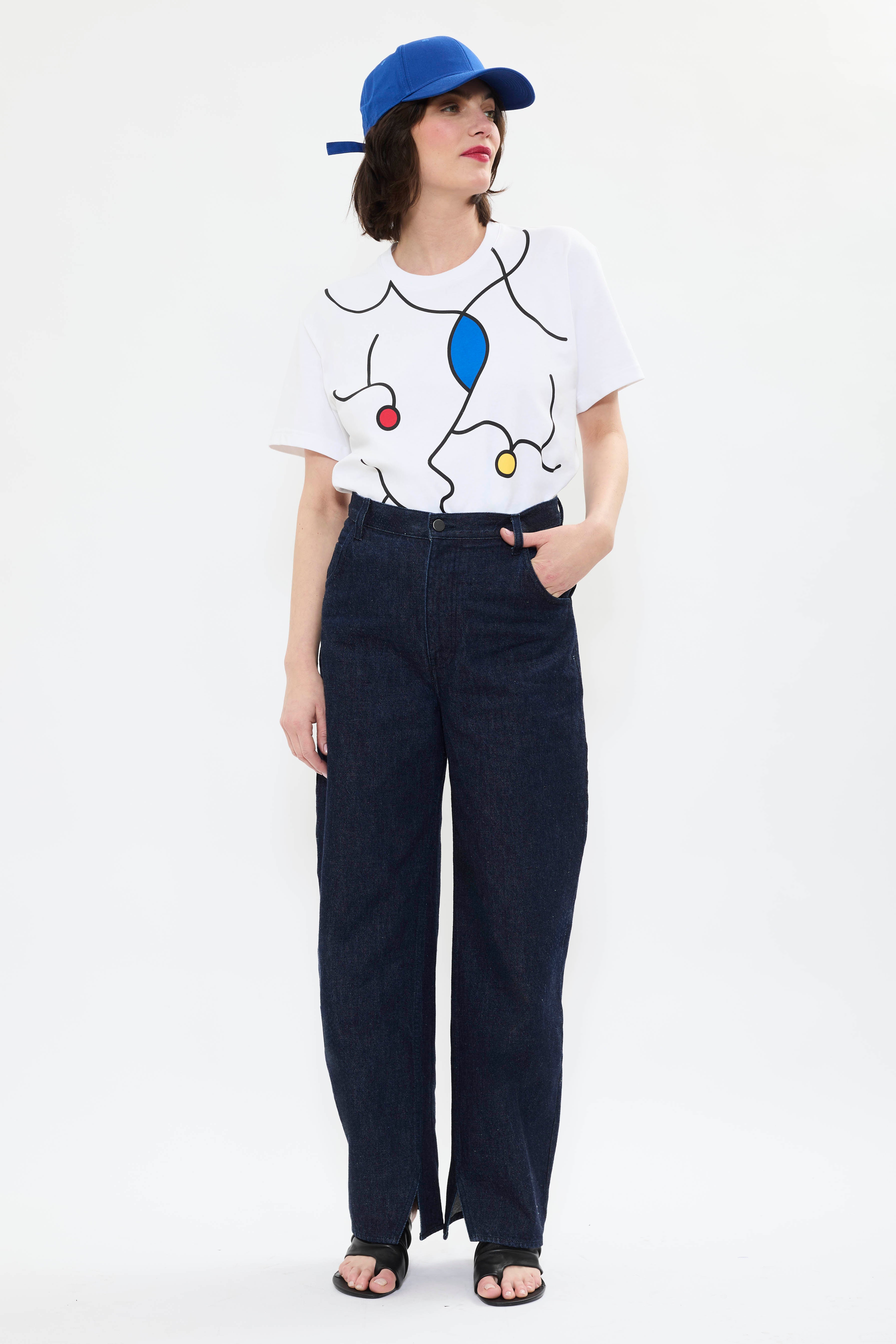 Model in AYT Studio x French painter REMED T-shirt in 100% organic cotton embellished in line art design with straight oversized fit and round neckline. Inspired by 'Oscillant silence, si dense.' Styled with AYT Studio 'SIGNATURE CAP'